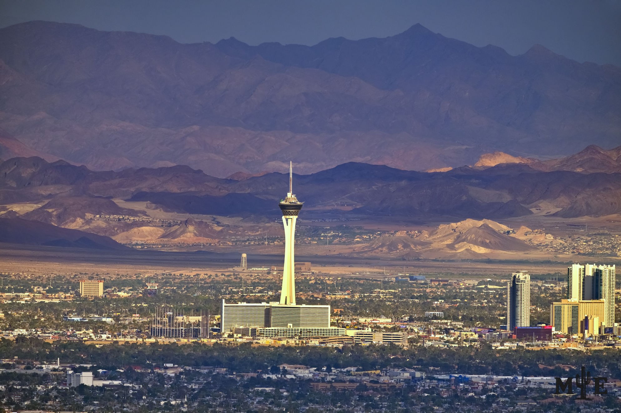 Prominent capture of the stratosphere making it look like an ivory tower among layered mountains and a dark Las Vegas valley.