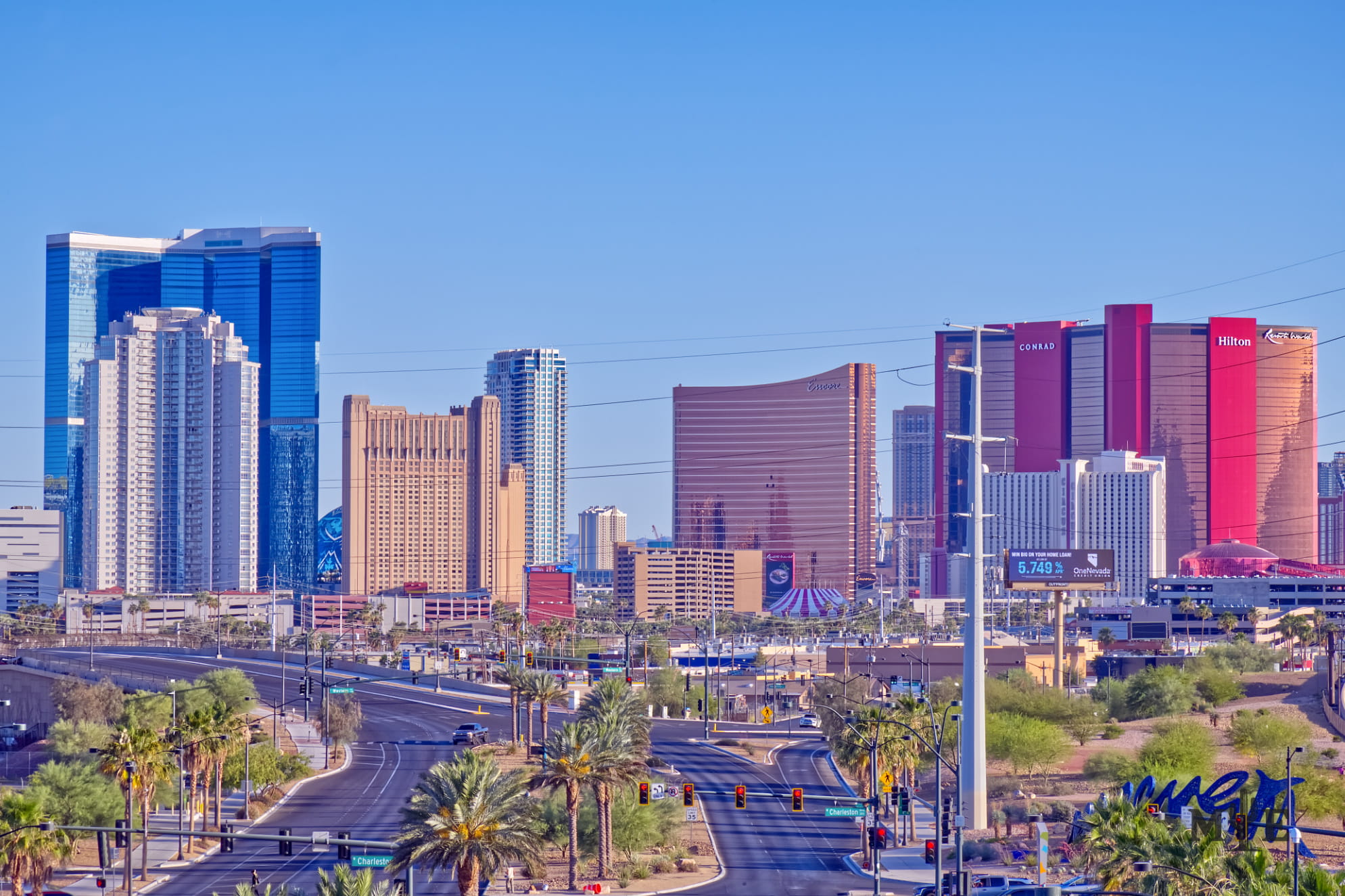 World renowned hotels tower over the city below under a blue sky with conventional city life in the foreground.
