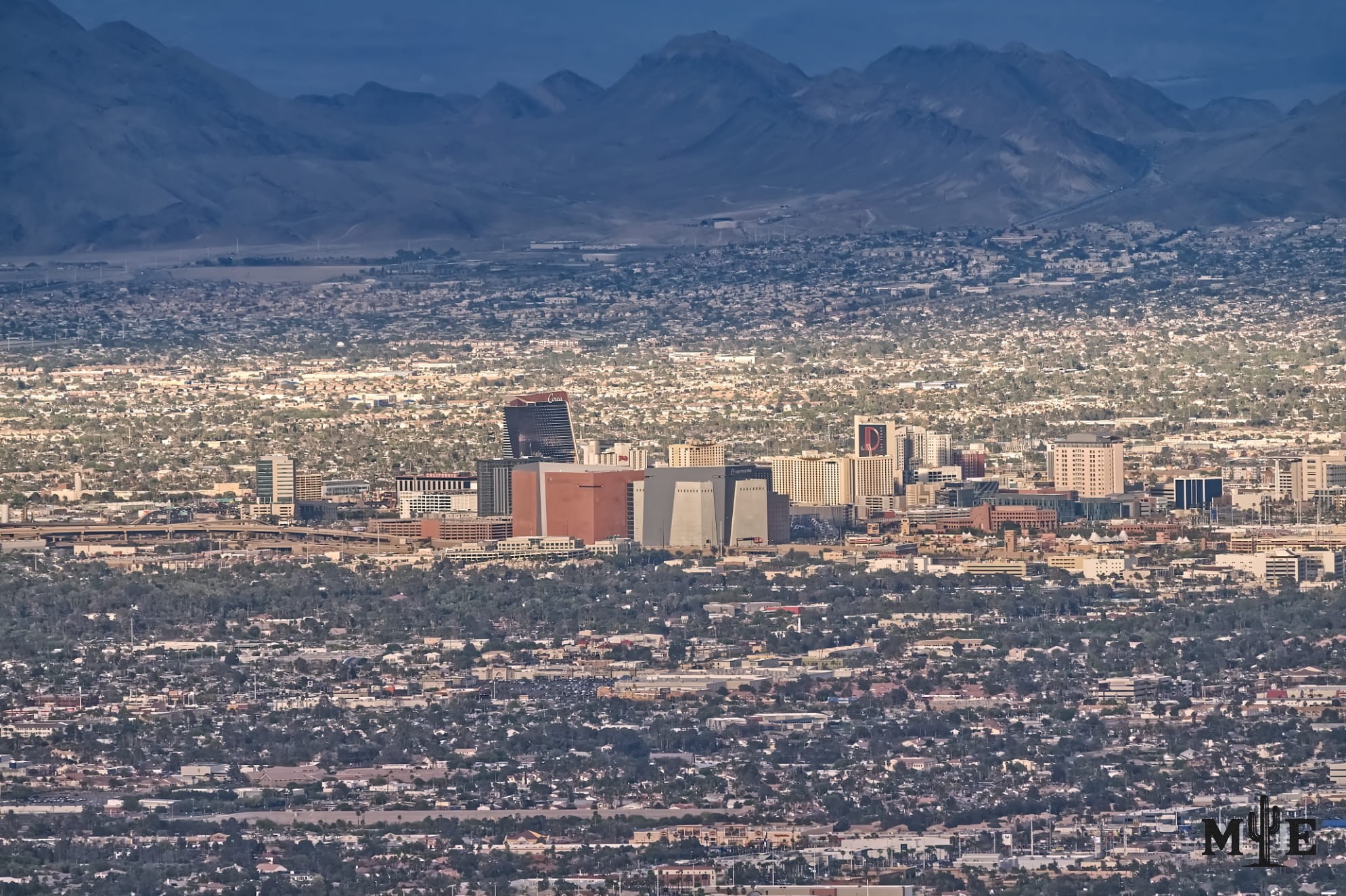 Telephoto photography of downtown Las Vegas front and center, surrounding metropolitan area and mountainous background.