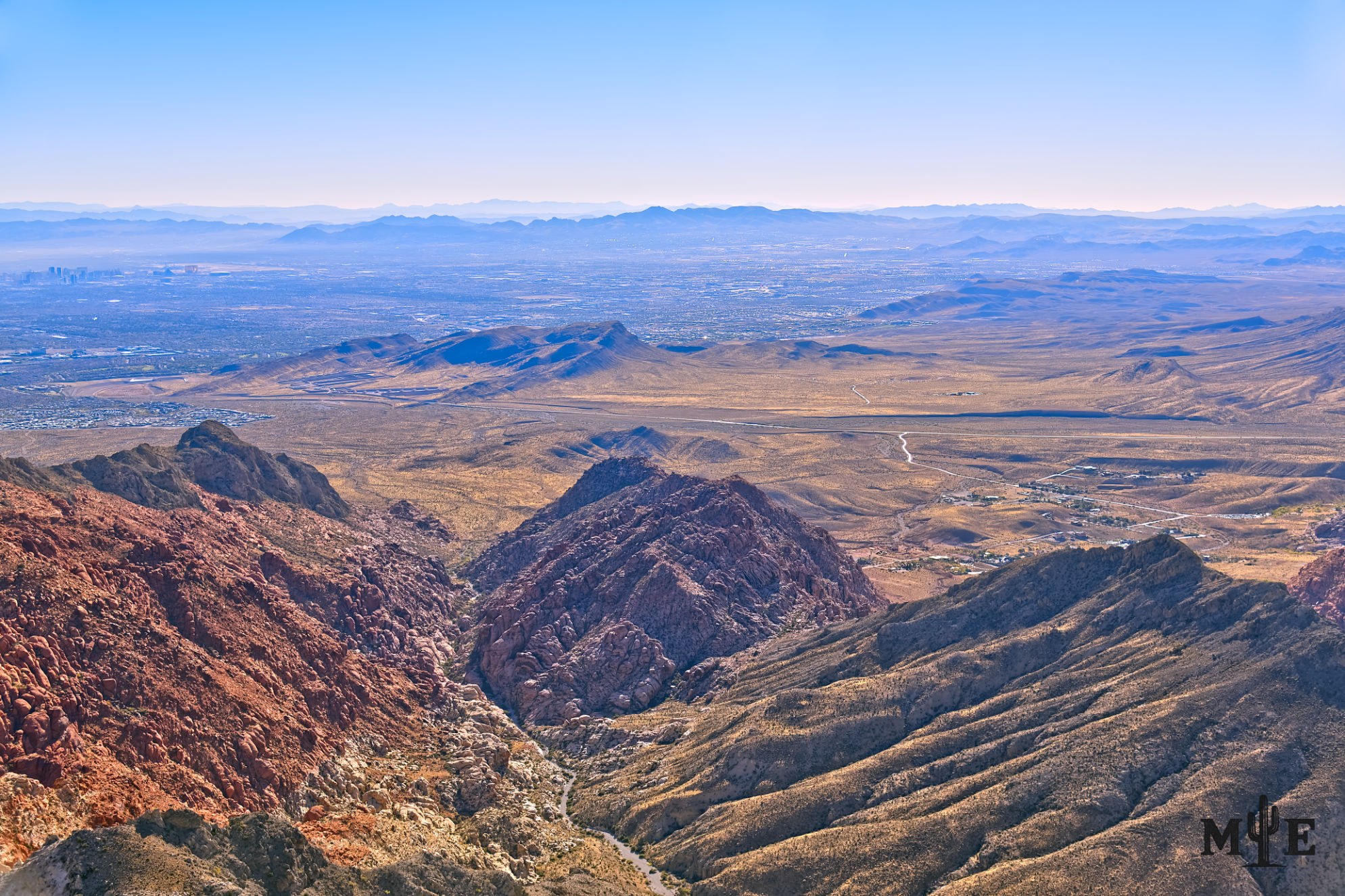 Rugged Red Rock Canyon ravine above the Nevada desert and southwest Las Vegas, with the metro area in the distance.