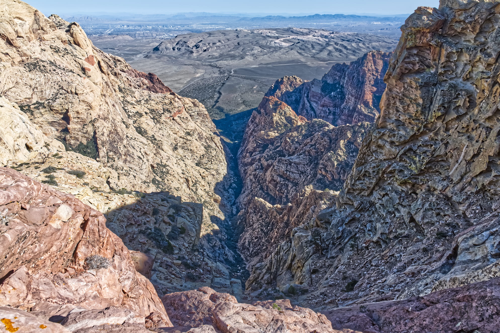 Jagged rocks line the walls of this rugged mountainous overlook in Red Rock Canyon. Las Vegas Valley in the distance.