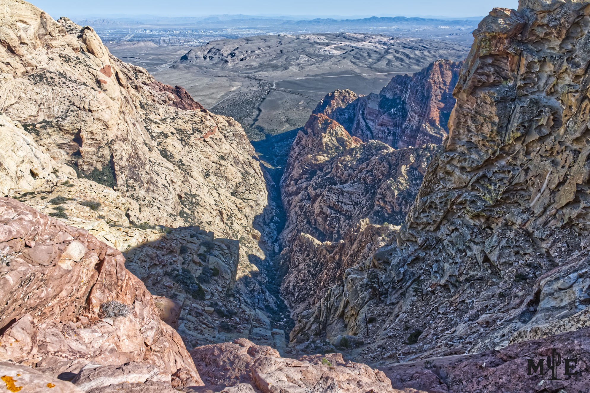 Jagged rocks line the walls of this rugged mountainous overlook in Red Rock Canyon. Las Vegas Valley in the distance.