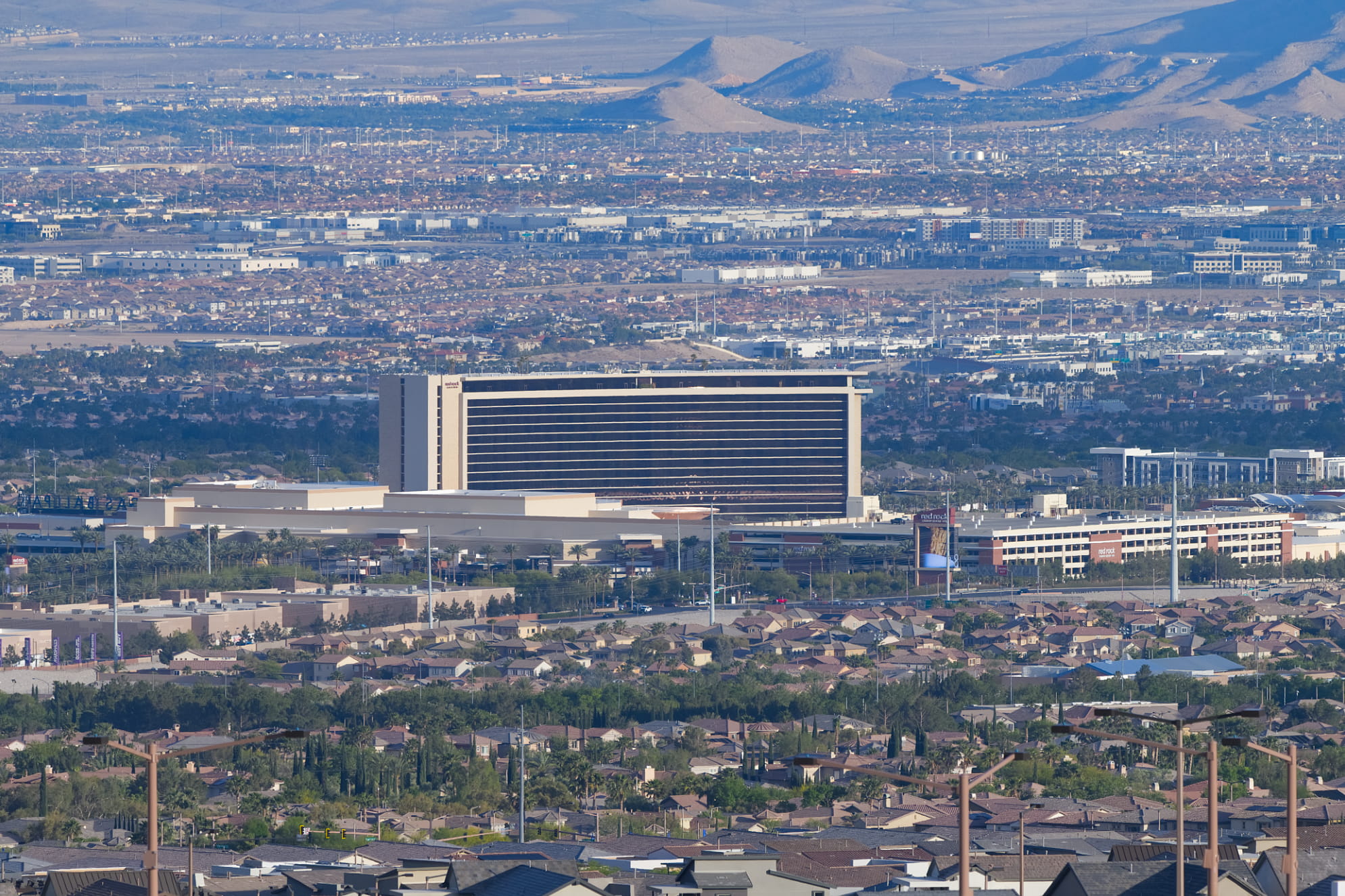 Red Rock Hotel and Casino front and center with the Las Vegas Valley surrounding it. Indicative of a busy metro area.
