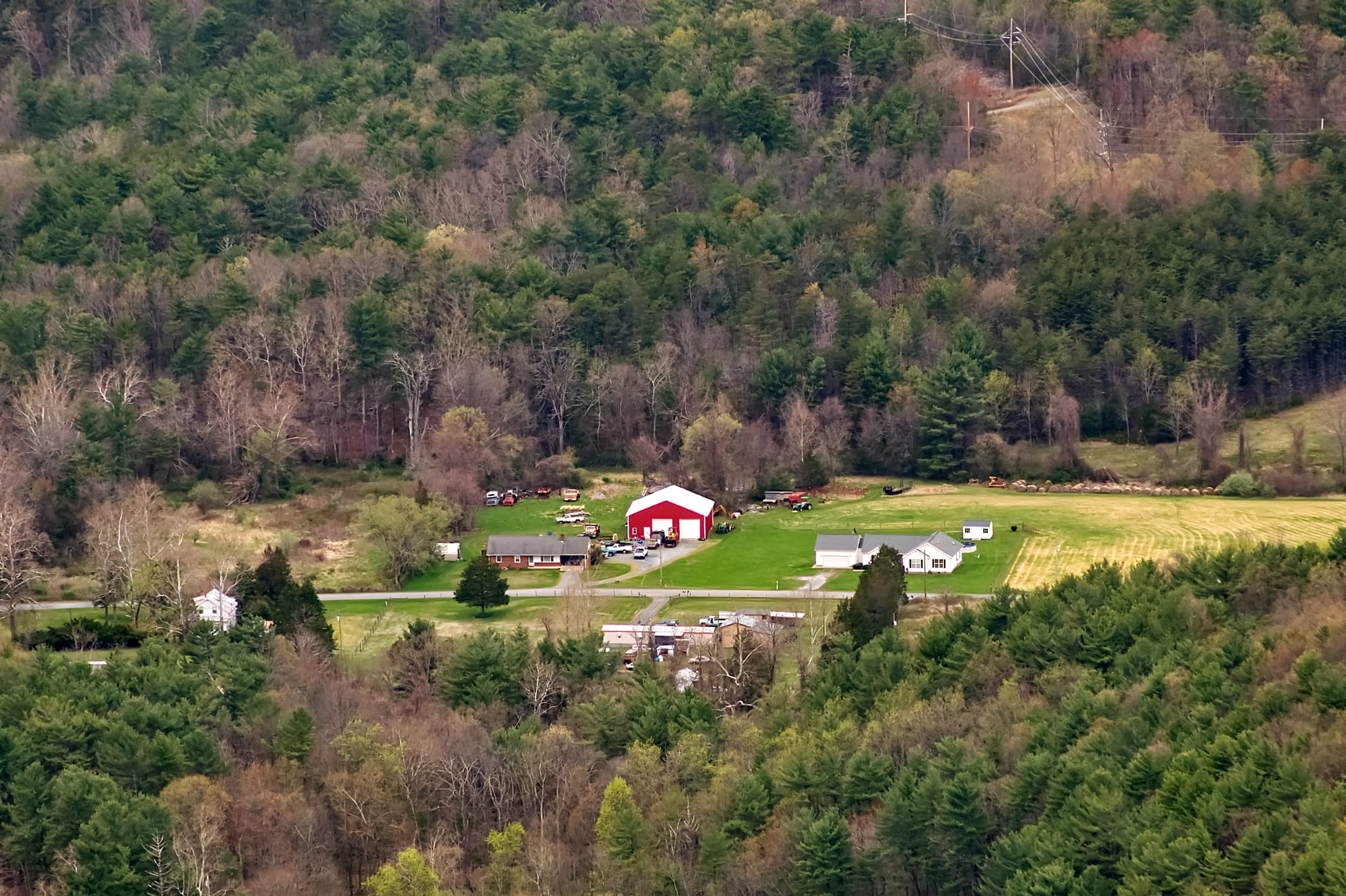 Dense Shenandoah National Park forest with red barn homestead on a clearing in the middle. Rural living old barn.