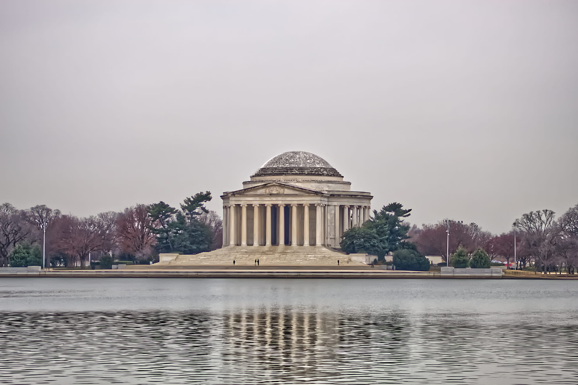 Jefferson Memorial photographed on an overcast day wtih glass like Potomac River in the foreground.