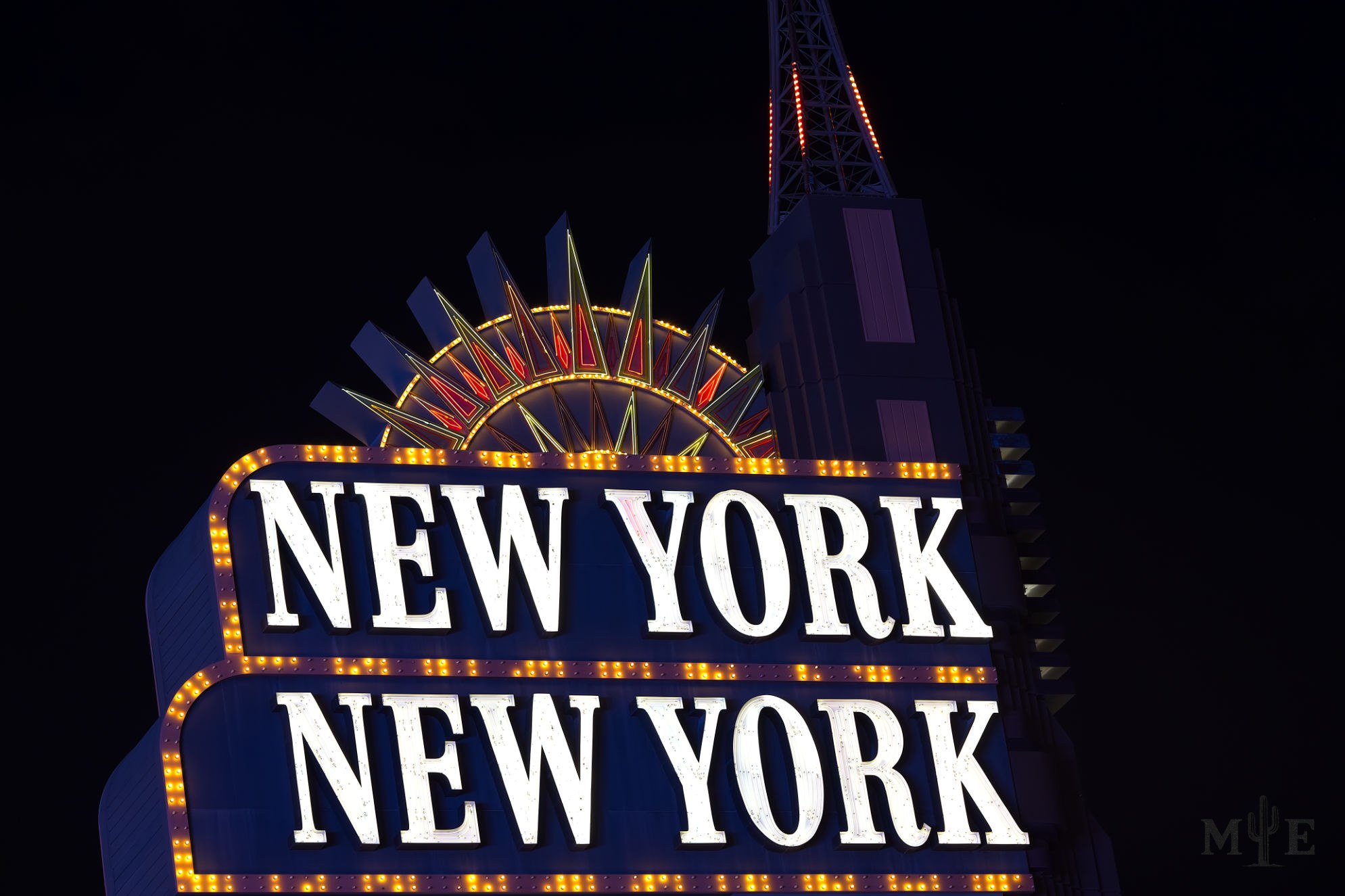 Purple outlined New York New York hotel signage on a pitch black night background.