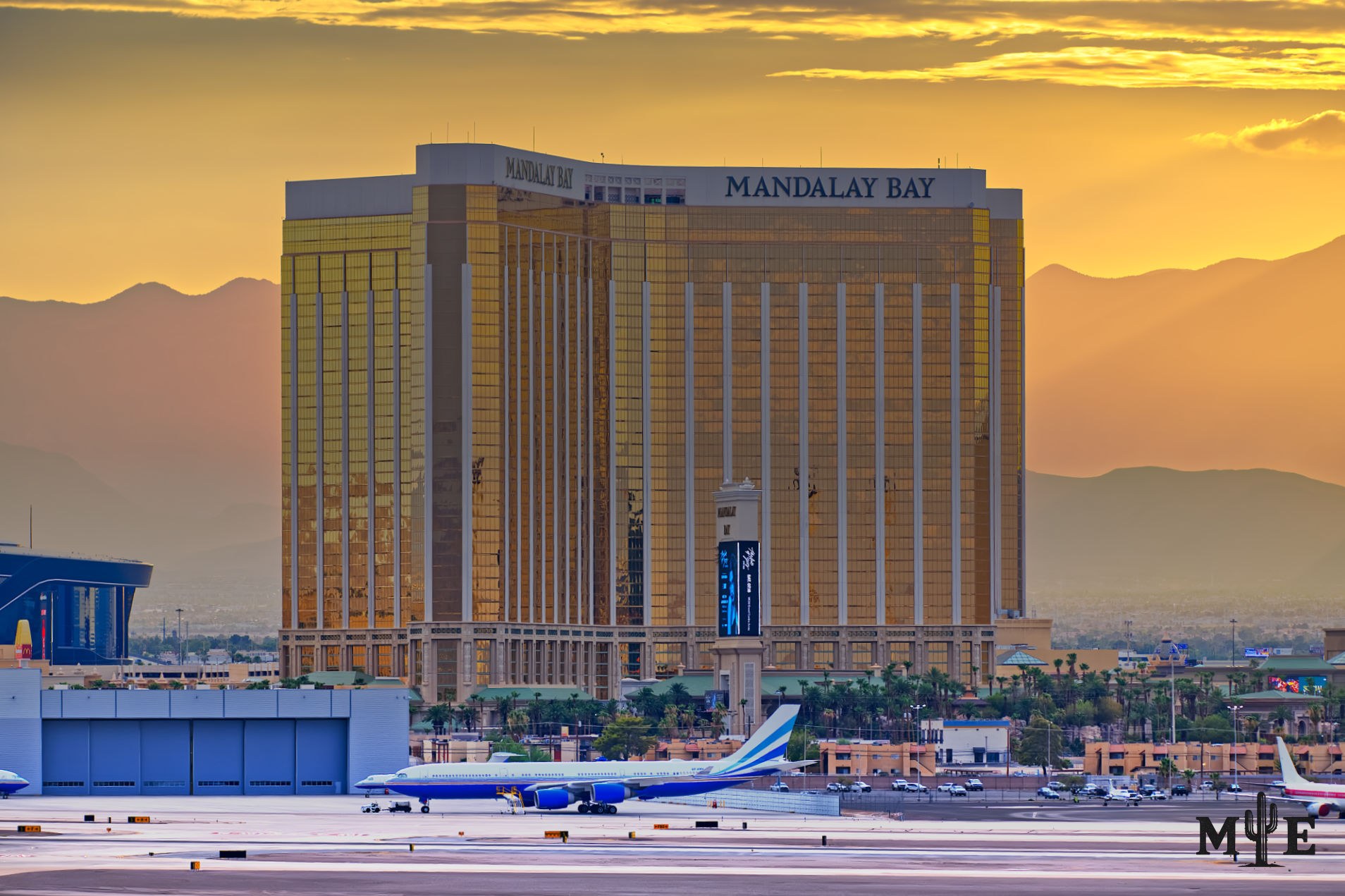 Heavenly sunset with gradient covered mountains and background. Mandalay Bay in foreground with passenger jet on runway.