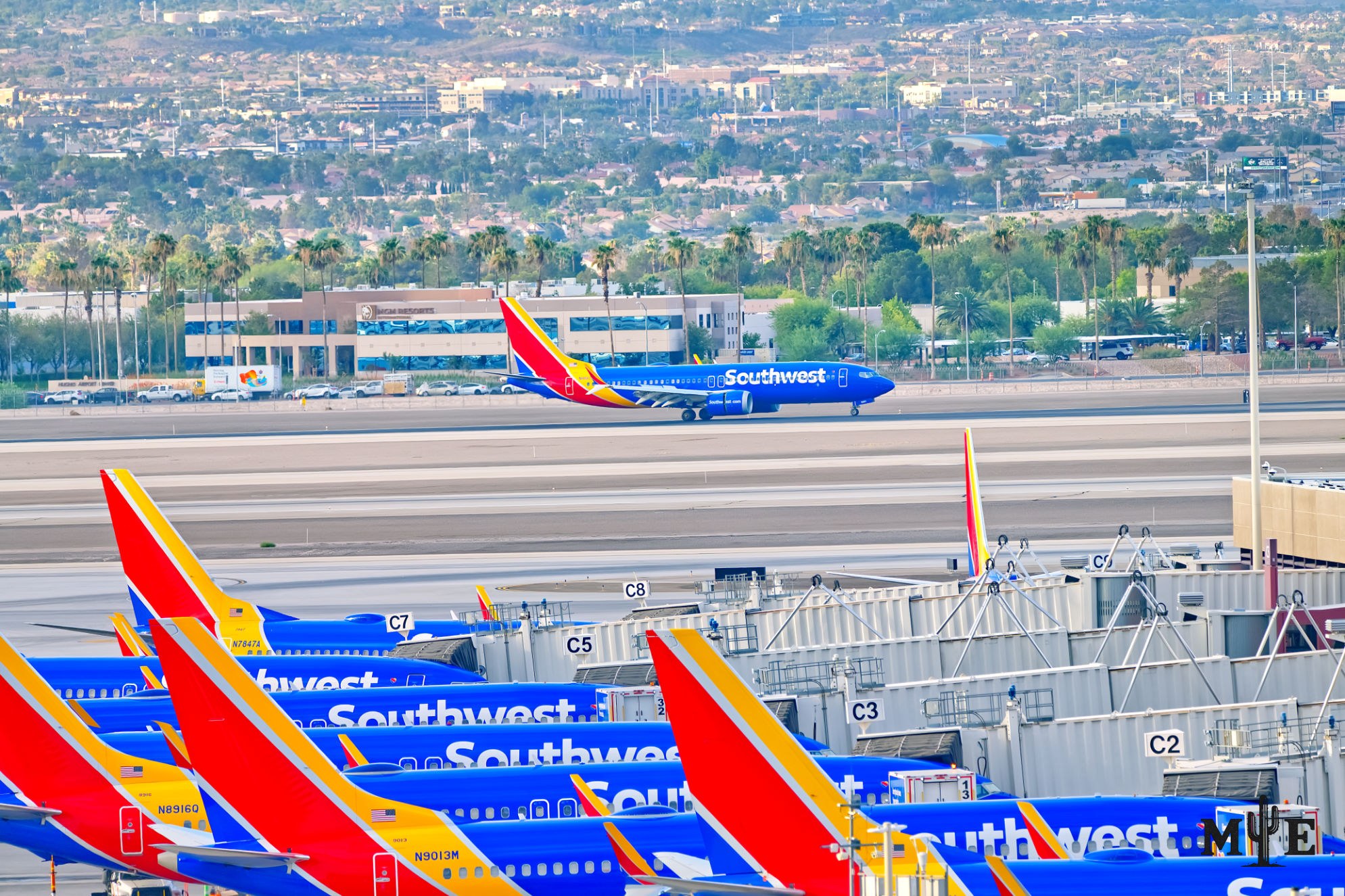 More than half a dozen Southwest Airlines jets clustered on a Las Vegas runway as another aircraft departs.